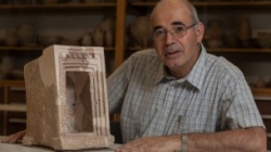 Yosef Garfinkel with a shrine model made of stone, found at Hirbet Qeiyafa (Courtesy Hebrew University of Jerusalem)